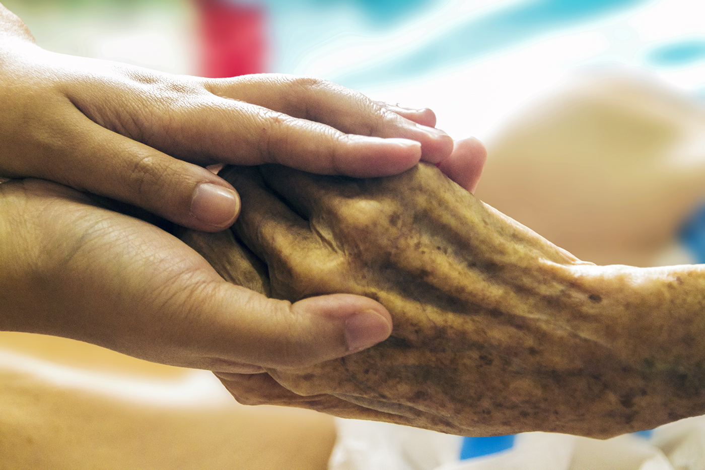 Thanadoula tenant la main d’une personne âgée en fin de vie à domicile
